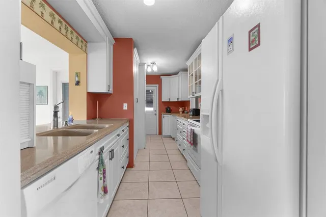 a large white kitchen with granite countertop a sink