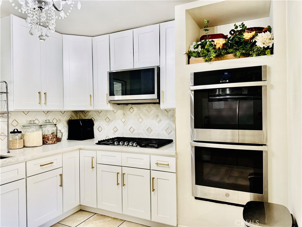 8735 Calaveras Avenue Rancho Cucamonga, CA 91730 - Photo 12 of 52 a kitchen with white cabinets and appliances