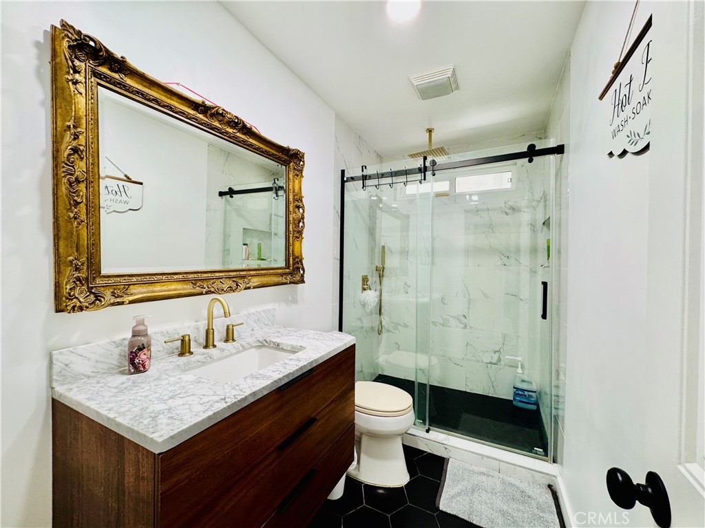 8735 Calaveras Avenue Rancho Cucamonga, CA 91730 - Photo 19 of 52 a bathroom with a sink vanity granite toilet and a mirror