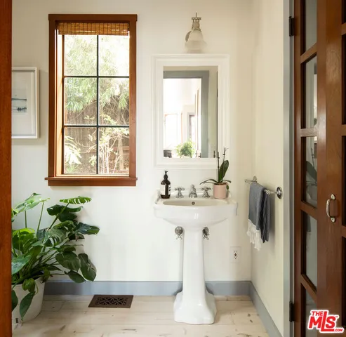 a bathroom with a sink a mirror and a window