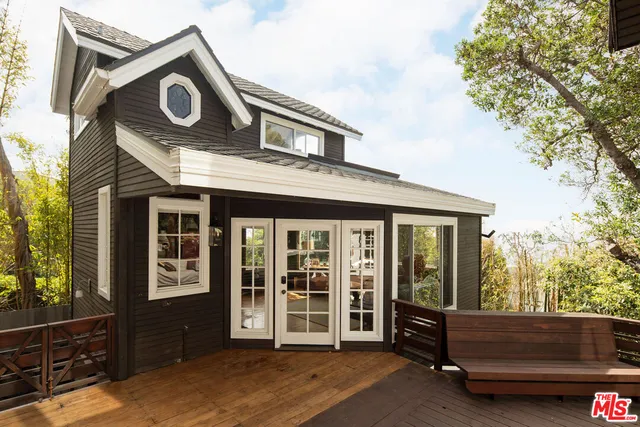 a view of a house with a large window and wooden fence