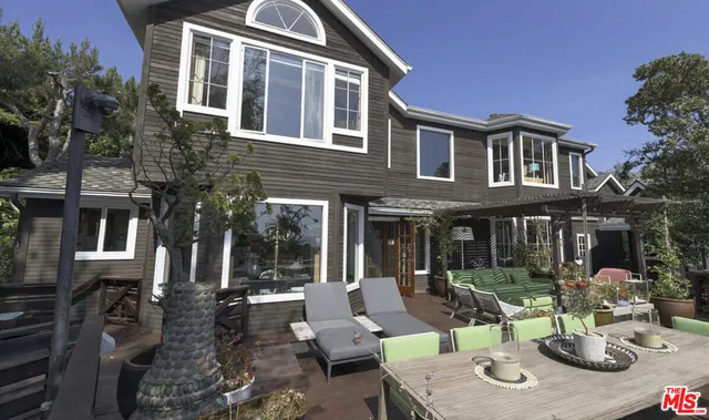 a view of a patio with couches table and chairs and potted plants