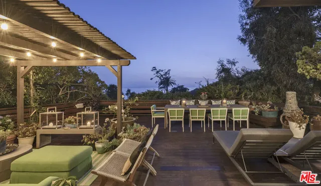 a view of a patio with couches table and chairs and potted plants