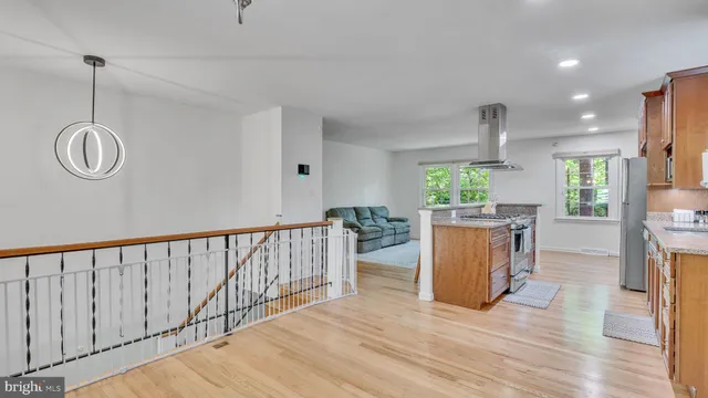 a open kitchen with lots of counter space cabinets and wooden floor