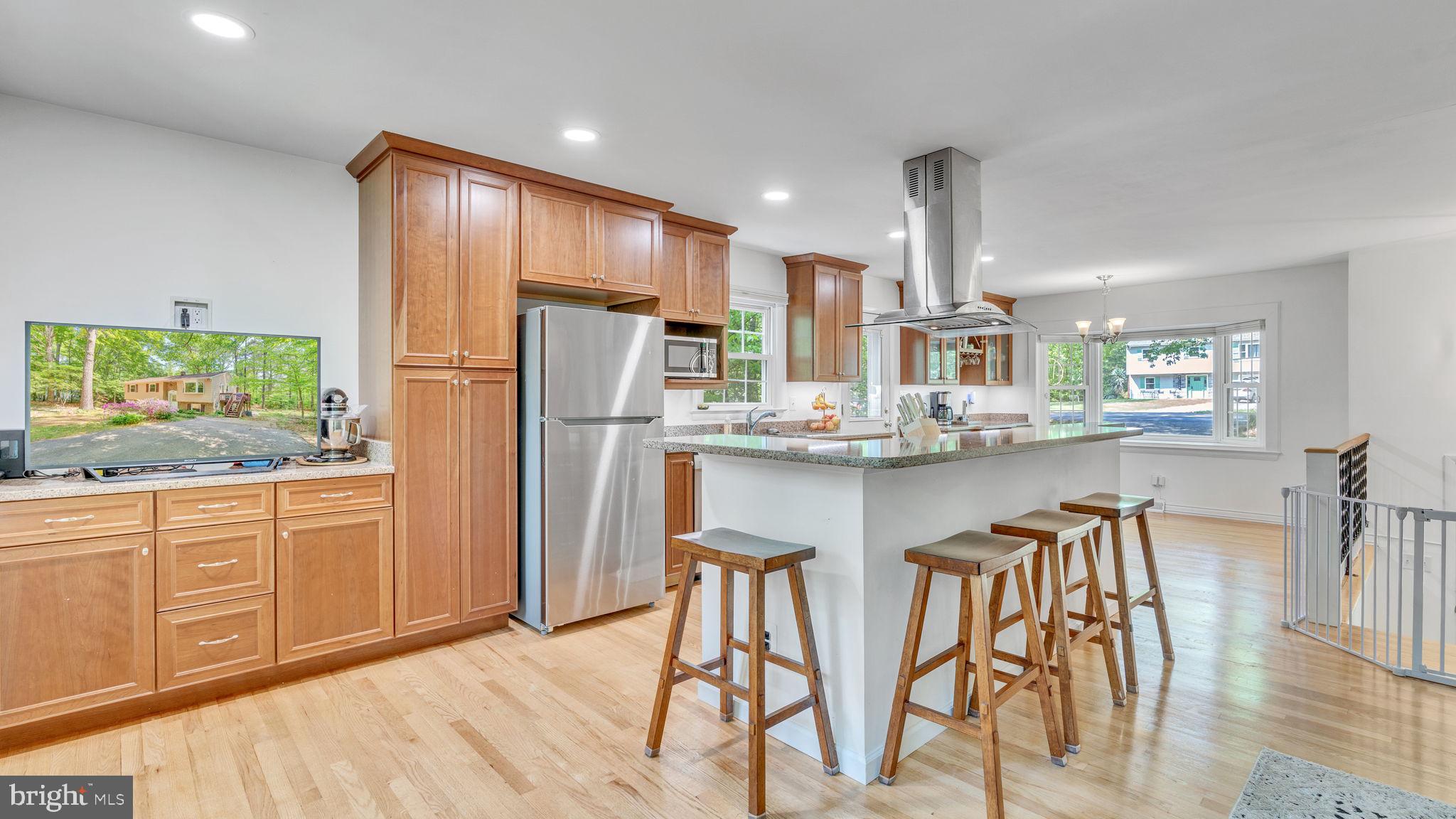 24680 Morgan Road Hollywood, MD 20636 - Photo 4 of 34 a kitchen with stainless steel appliances granite countertop a refrigerator a sink dishwasher a dining table and chairs with wooden floor