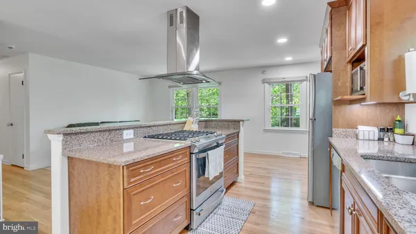 a kitchen with stainless steel appliances granite countertop a sink stove and cabinets