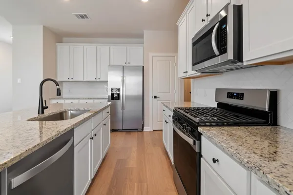 a kitchen with stainless steel appliances granite countertop a sink stove and refrigerator