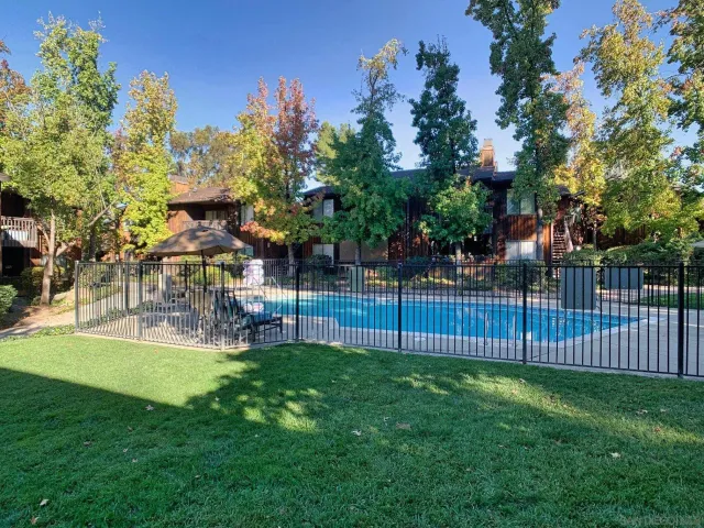 a patio with a table and chairs under an umbrella