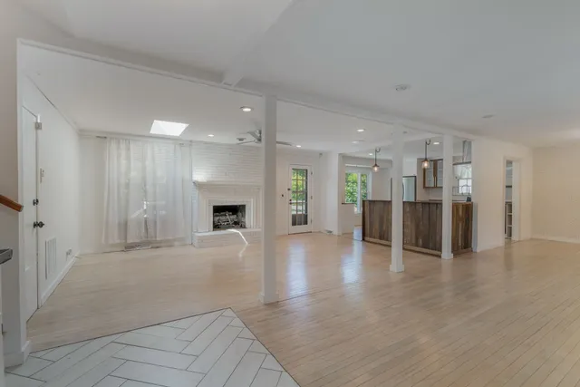a view of a big room with wooden floor and a kitchen