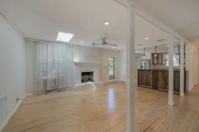 an empty room with wooden floor and fireplace