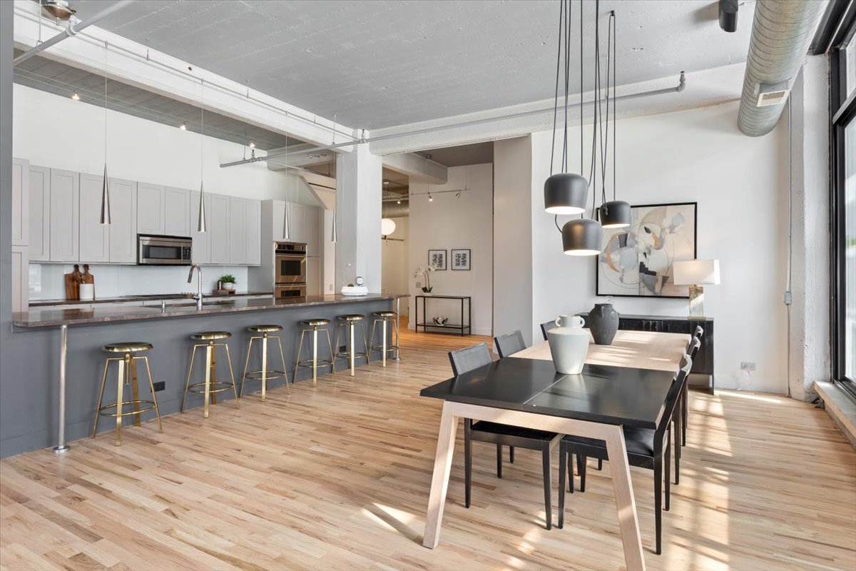 850 West Adams Street, Unit 4A Chicago, IL 60607 - Photo 19 of 52 a open kitchen with stainless steel appliances kitchen island granite countertop a table chairs and a refrigerator