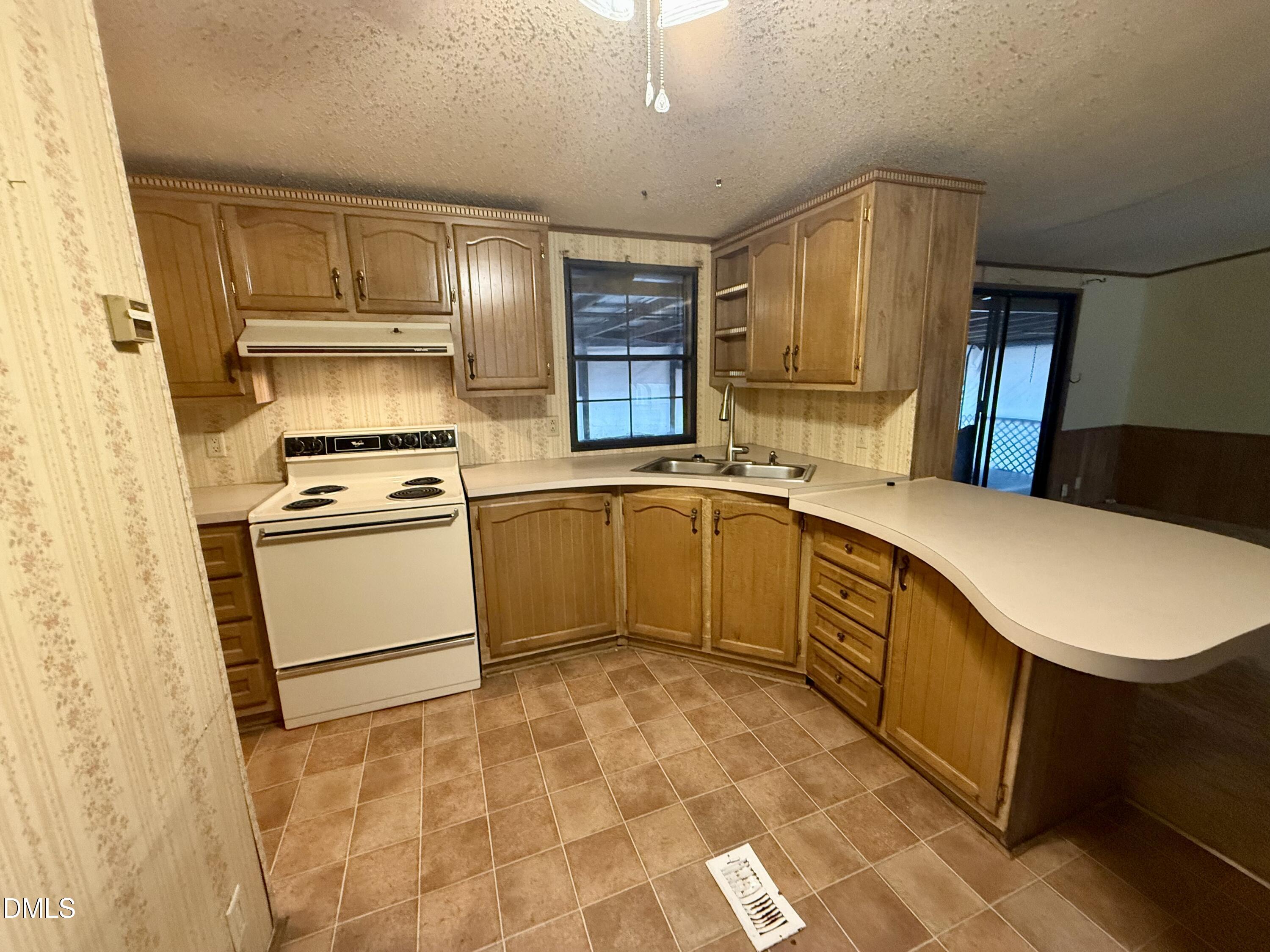 1969 Bagley Road Kenly, NC 27542 - Photo 16 of 23 a kitchen with a stove a sink and a refrigerator