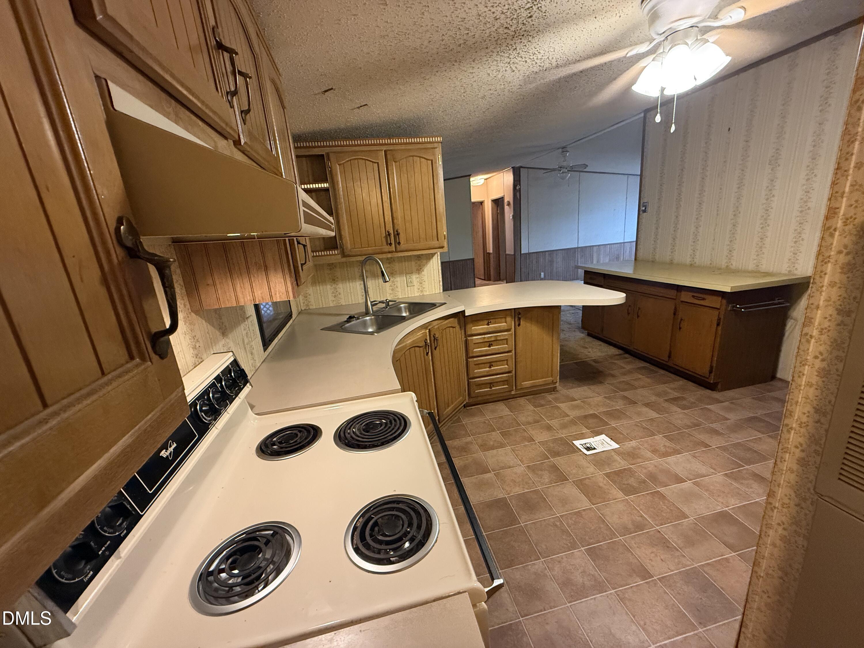 1969 Bagley Road Kenly, NC 27542 - Photo 17 of 23 a kitchen with a refrigerator a sink a stove and cabinets
