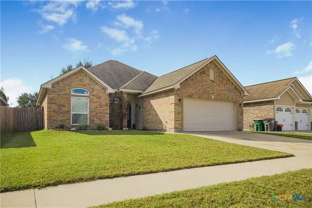 a view of a house with a yard and garage