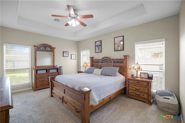 a bedroom with a bed and a table in it with window