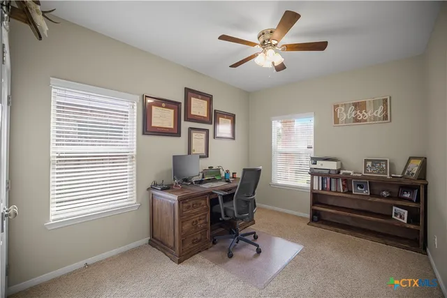 a view of a workspace with furniture and a window