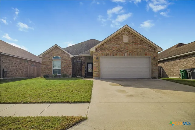 a view of a house with a yard and garage