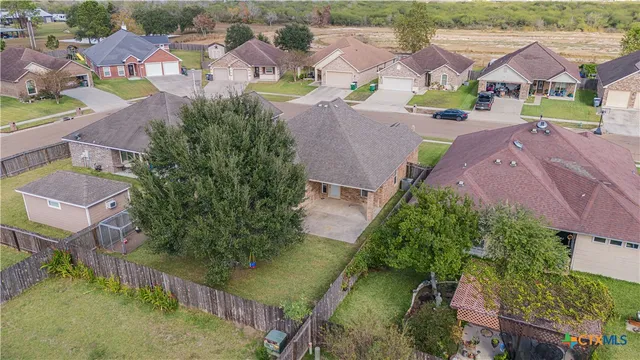 an aerial view of residential houses with outdoor space and parking