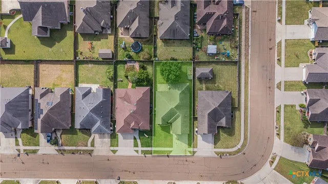 an aerial view of residential houses with outdoor space and parking