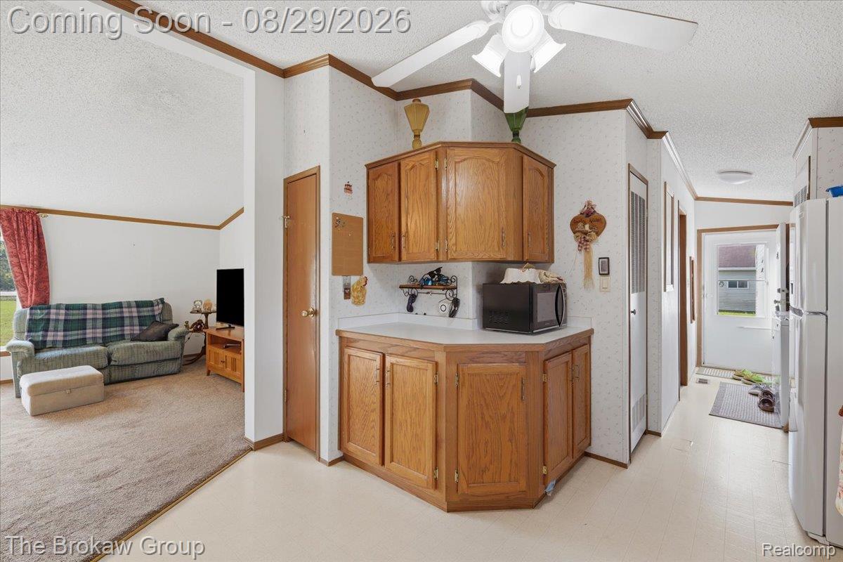 5189 North Webster Road Flushing, MI 48433 - Photo 21 of 46 Corner kitchen cabinetry with white countertops, white ceiling fan, and light-toned flooring