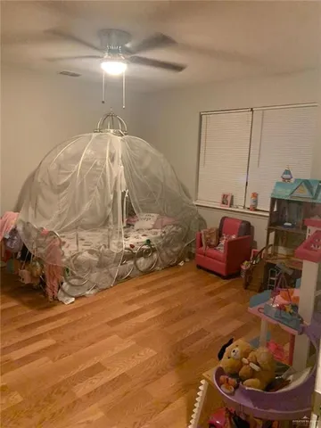 a room with a large bed and wooden floor