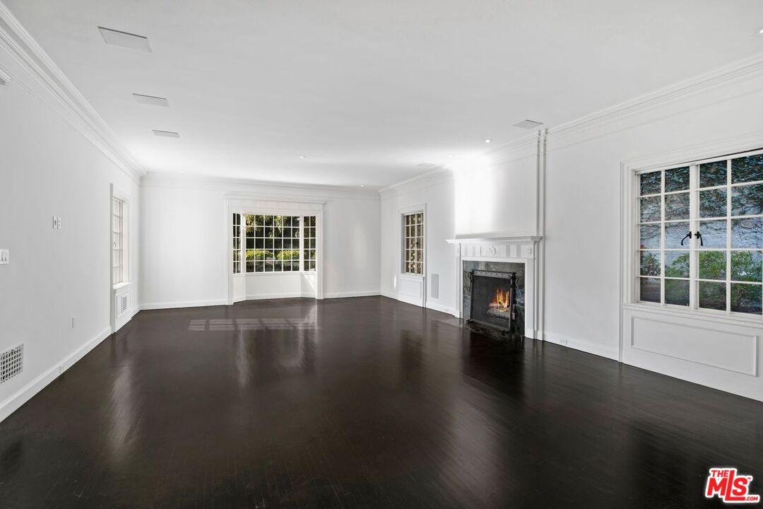 1910 Outpost Drive Los Angeles, CA 90068 - Photo 5 of 27 an empty room with wooden floor fire place and windows