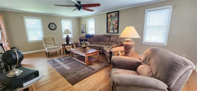 a living room with furniture kitchen view and a flat screen tv