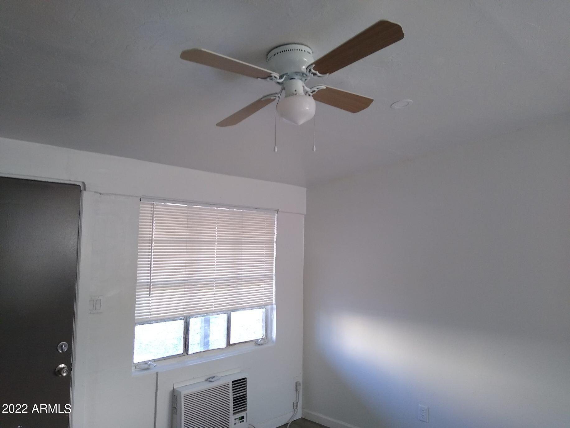 1629 East Pinchot Avenue Phoenix, AZ 85016 - Photo 3 of 9 an empty room with windows and fan