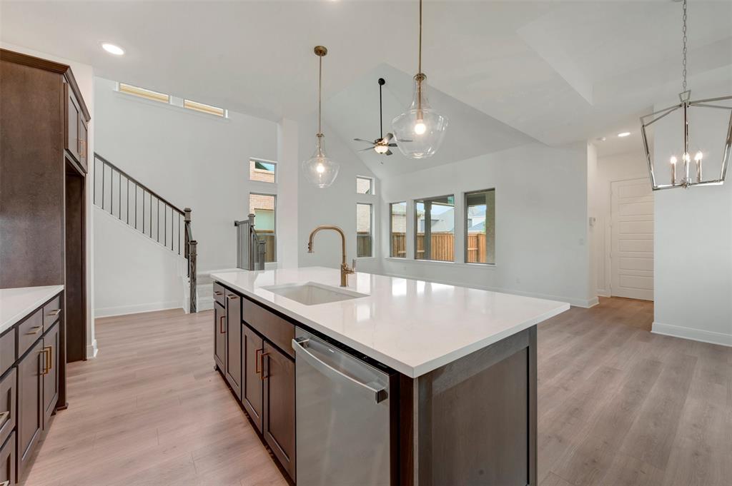 1908 Cola Drive Van Alstyne, TX 75495 - Photo 18 of 29 Kitchen island featuring a white countertop, undermount sink, and brass-finish faucet
