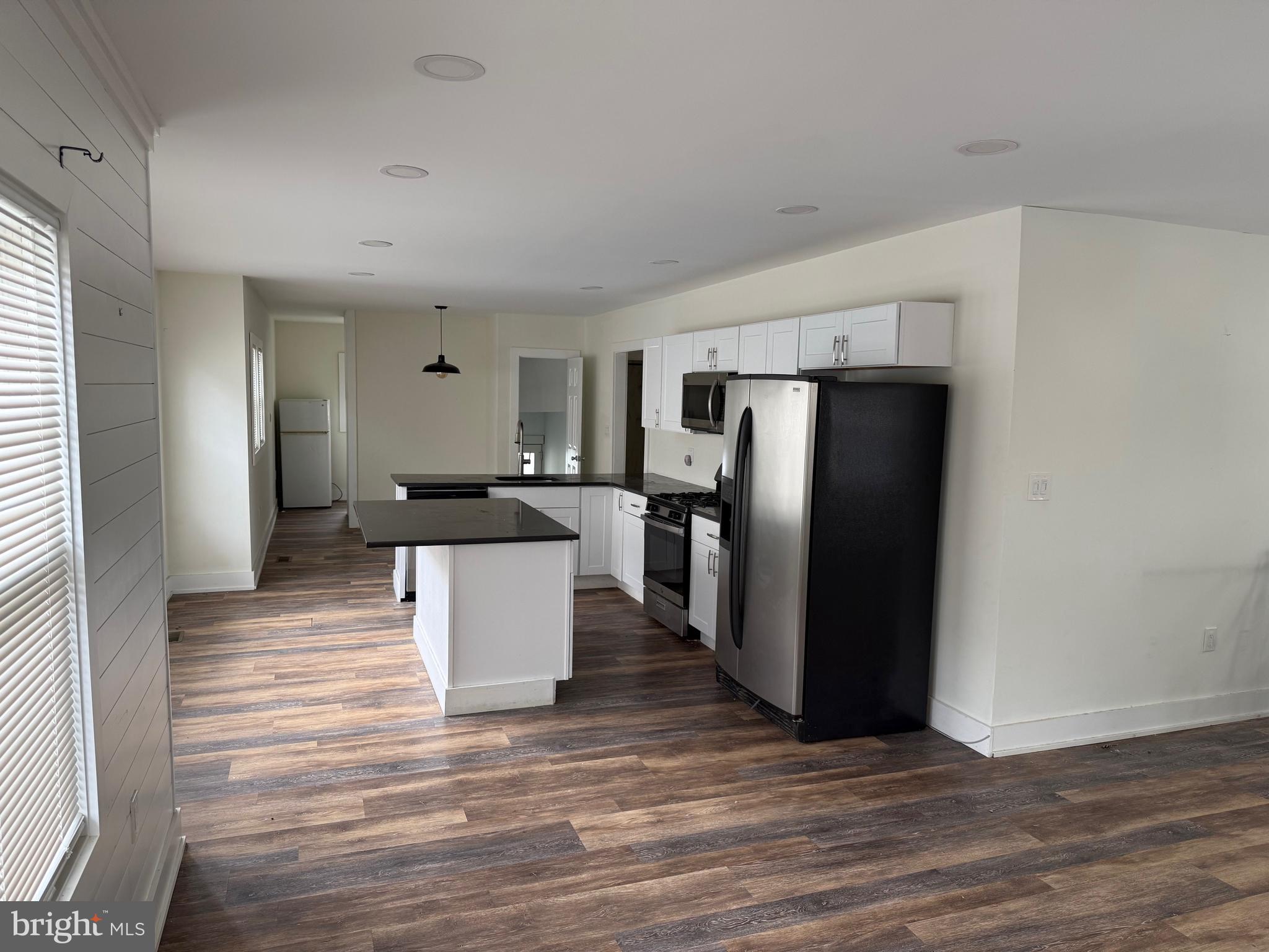 132 Walnut Street Westville, NJ 08093 - Photo 5 of 23 a kitchen with stainless steel appliances a refrigerator and a wooden floor