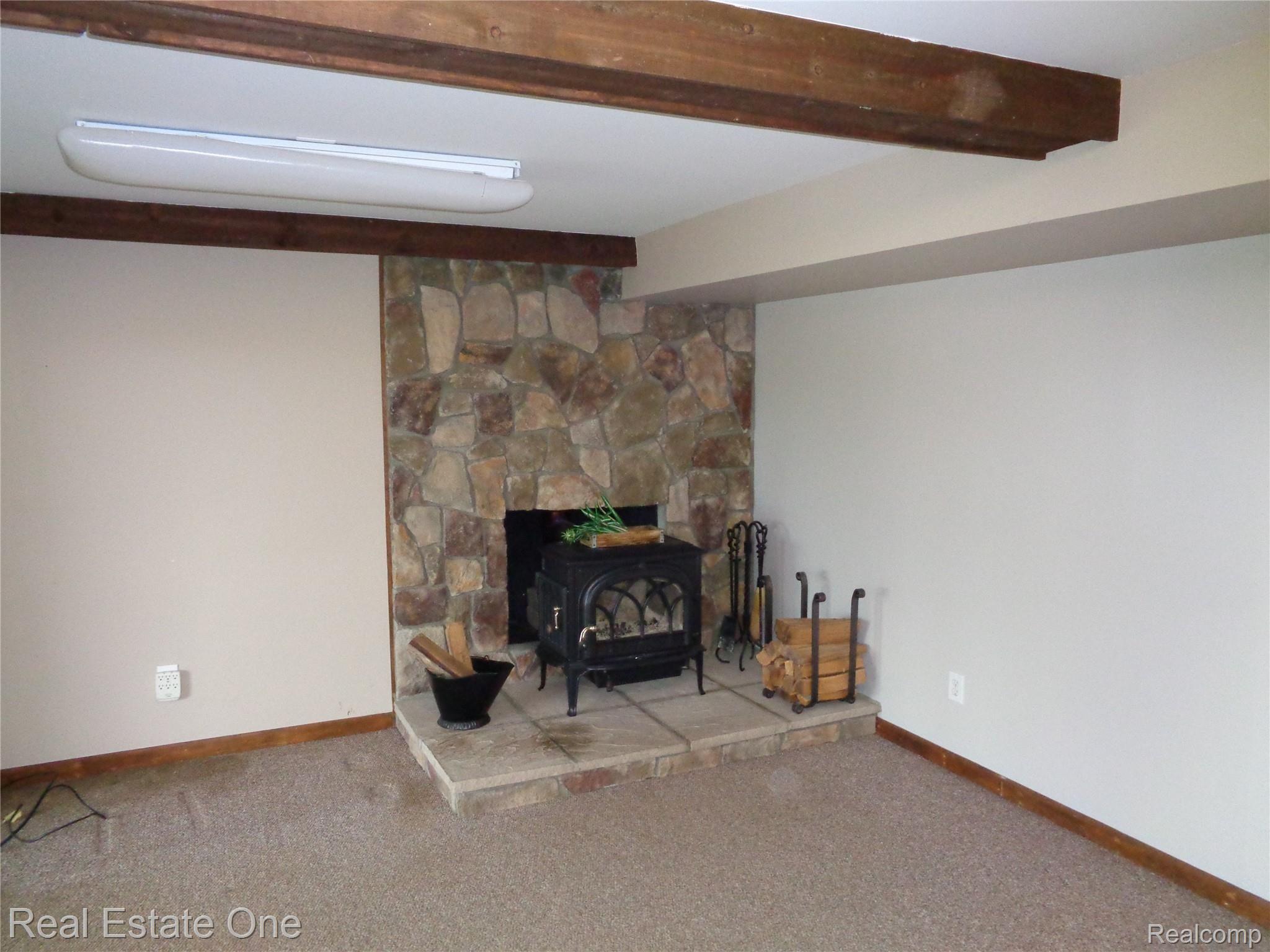 2572 Lake George Road Oakland, MI 48363 - Photo 45 of 83 Finished lower level family room with wood beams & 2nd wood burning fireplace