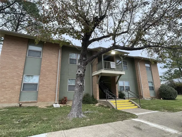 a view of a house with a yard garage and tree