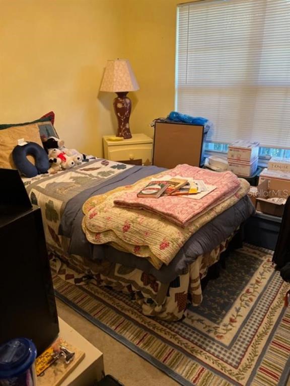 330 Promenade Drive, Unit 206 Dunedin, FL 34698 - Photo 18 of 31 a bedroom with a bed and wooden floor