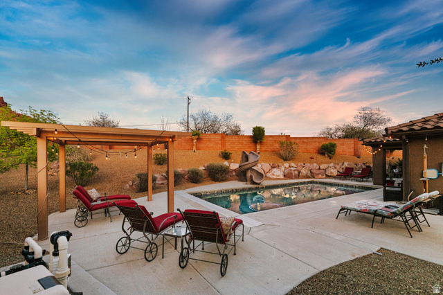 210 Talon Court Ivins, UT 84738 - Photo 43 of 60 View of swimming pool featuring a pergola, patio surround, a water slide, and a fenced backyard