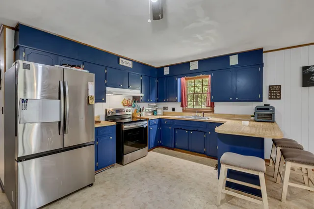 a kitchen with stainless steel appliances granite countertop a refrigerator sink and stove