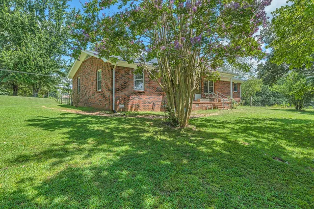 a backyard of a house with large trees and brick walls