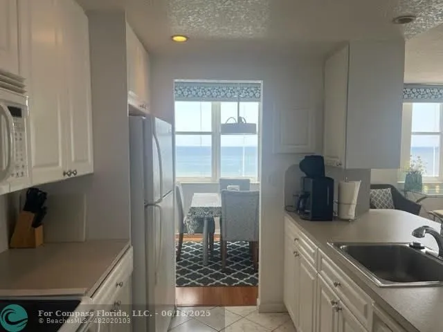 a kitchen with a sink a refrigerator and cabinets