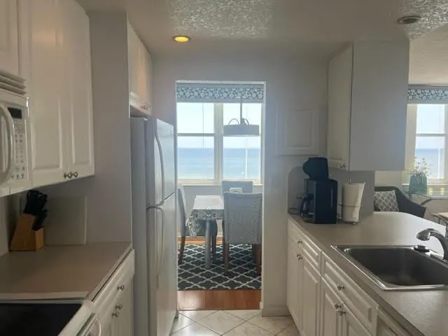 a kitchen with a sink a refrigerator and cabinets