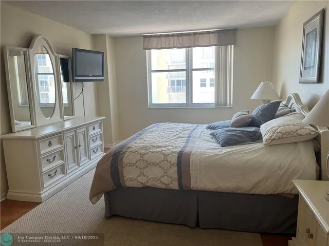 a bedroom with a bed window and mirror