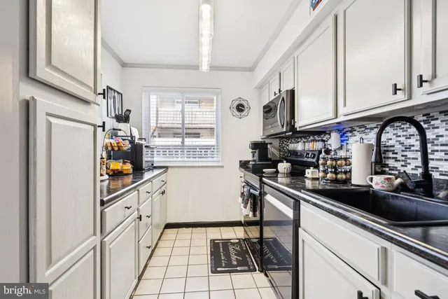 a kitchen with stainless steel appliances a sink a stove and cabinets