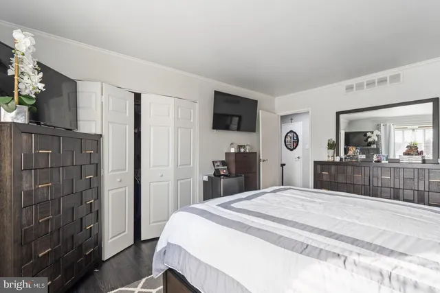 a large bedroom with a bed and a flat screen tv