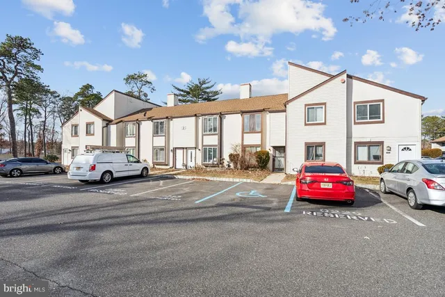 a white car parked in front of a white house
