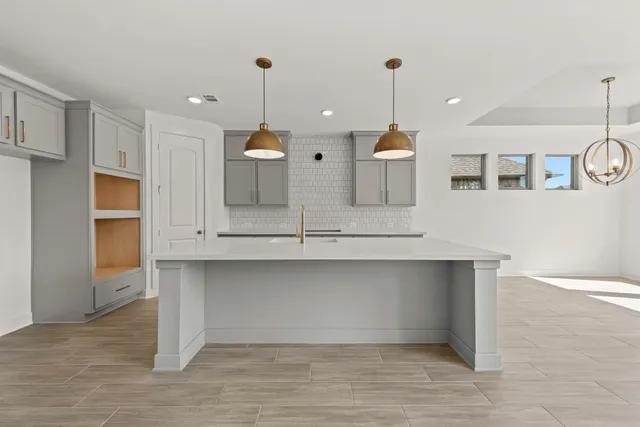 a view of a kitchen with kitchen island a sink stainless steel appliances and cabinets