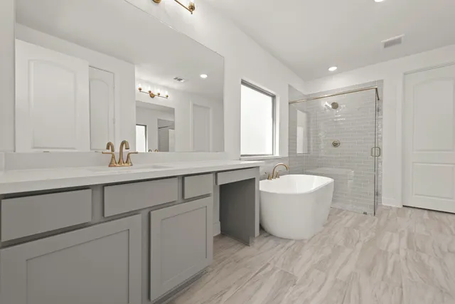 a spacious bathroom with a double vanity sink a mirror and a bathtub