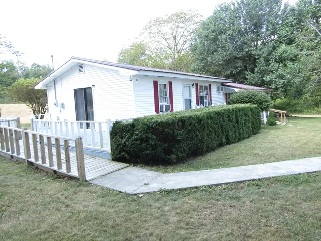 a view of a house with a yard and fence