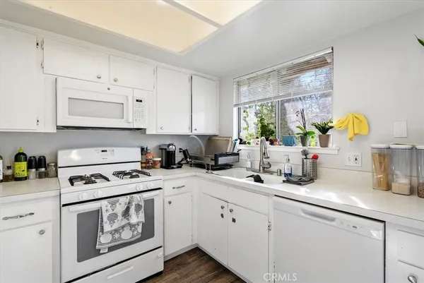 a kitchen with white cabinets and white appliances