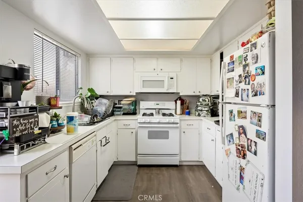 a view of a patio with table and chairs potted plants and a large tree