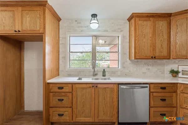 a kitchen with cabinets appliances a sink and a window