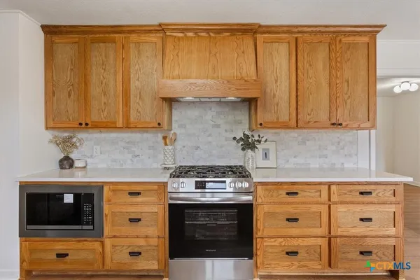 a kitchen with granite countertop a stove and a microwave