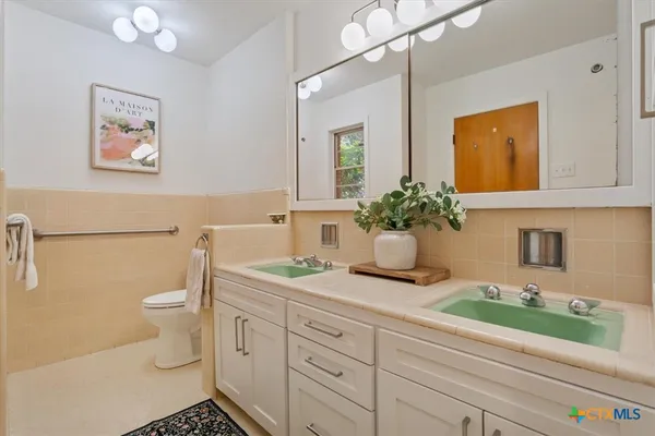 a bathroom with a granite countertop sink mirror and toilet